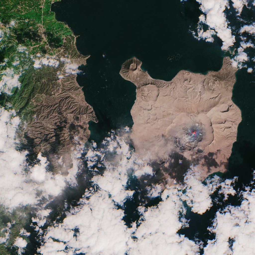 Drone Surveys Map Cooling Lava Fields After an Eruption Ends island volcano with ash cloud above dark lava fields reaching the sea