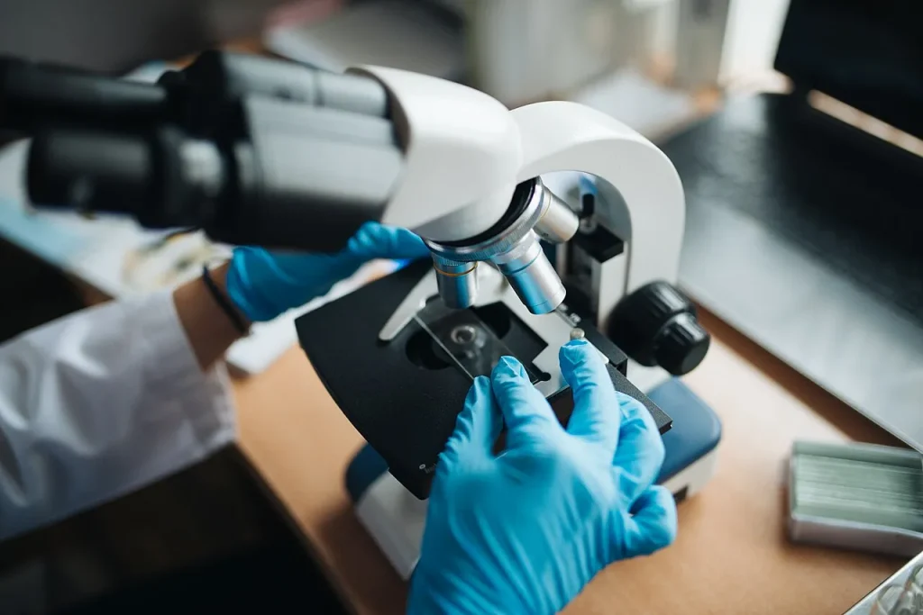 What Counts as Proof? The Unfinished Science of Microplastics in Bottled Water A laboratory technician adjusting a sample slide under a microscope