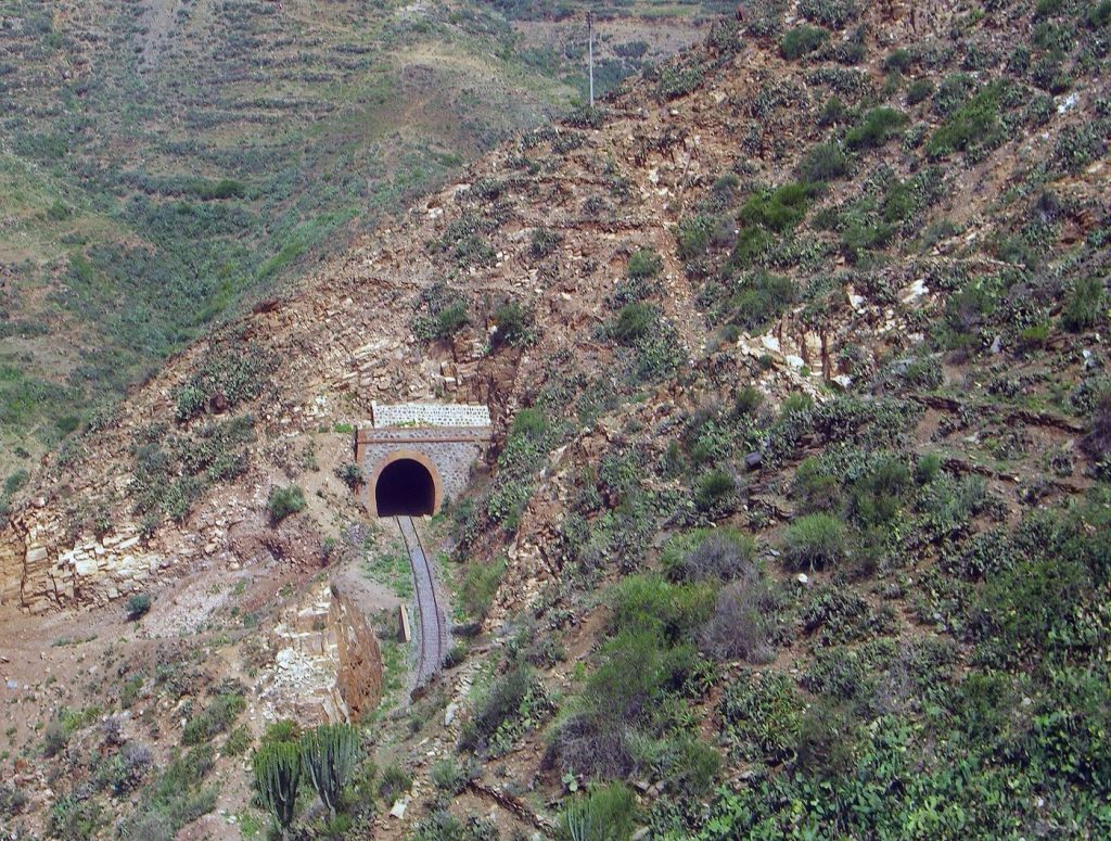 Alpine Rail Tunnels Promise to Take Freight Off Mountain Roads A train emerging in a mountain landscape